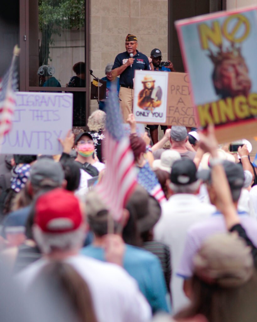 Speaker at rally with people holding signs